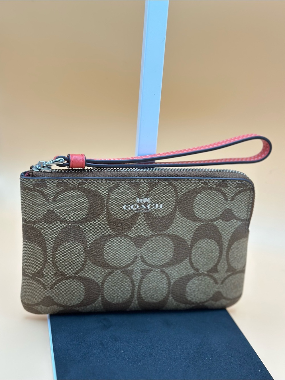 Coach Signature C wristlet in khaki/brown with coral-pink leather trim